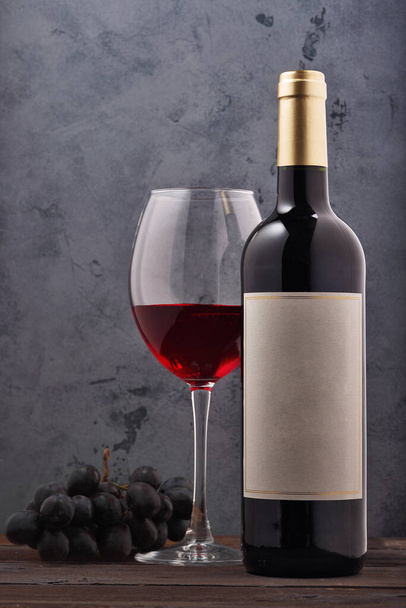Rotwein und Trauben. Wein und Trauben im Vintage-Ambiente mit Korken auf Holztisch - Foto, Bild