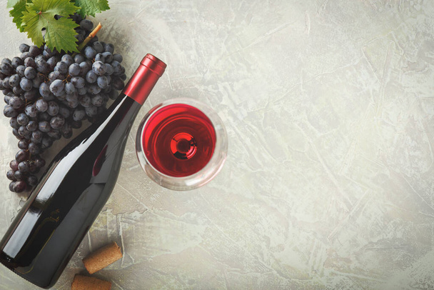 赤ワインとブドウ。木のテーブルの上にコルクでヴィンテージの設定でワインとブドウ - 写真・画像