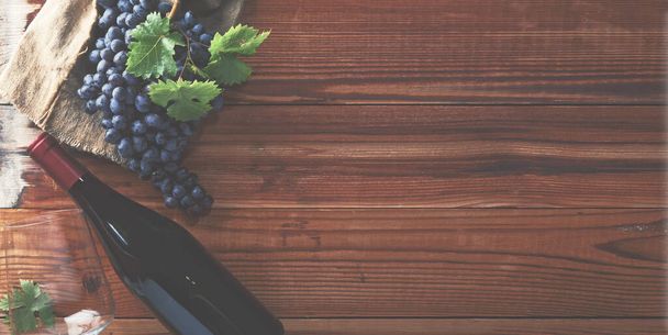 Vin rouge et raisins. Vins et raisins dans un cadre vintage avec bouchons sur table en bois. - Photo, image