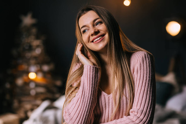 schöne stilvolle Mädchen im Pullover lächelnd und posiert im Weihnachtsinneren - Foto, Bild