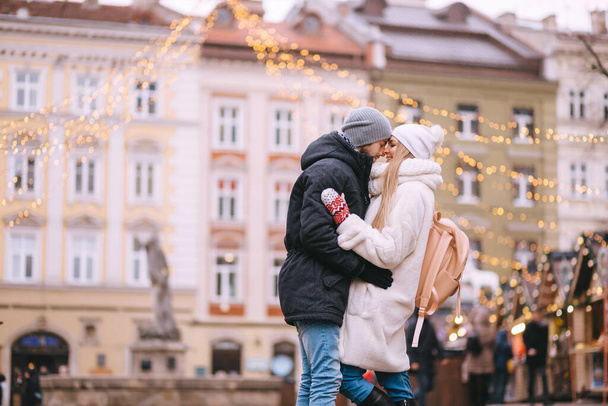 dovolená, zima, Vánoce a lidé koncept - šťastný pár v teplém oblečení procházky ve starém městě - Fotografie, Obrázek