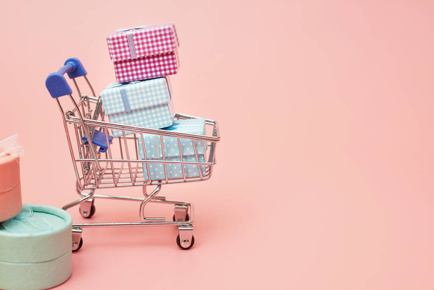 concept black friday, gift boxes with shopping cart on pink pastel background, copy space, flatlay - Foto, immagini