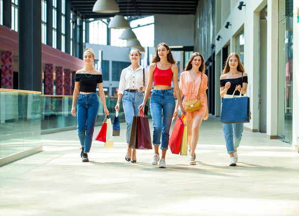 Five young girlfriends are walking in the mall with shopping bags - Foto, afbeelding