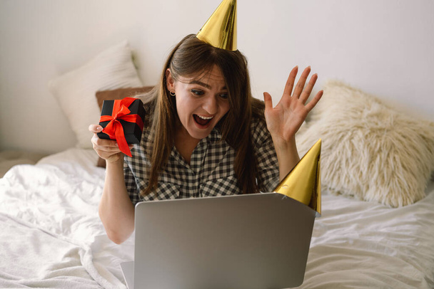 Beautiful girl celebrating birthday online in quarantine time through video call virtual party with friends.  - Φωτογραφία, εικόνα
