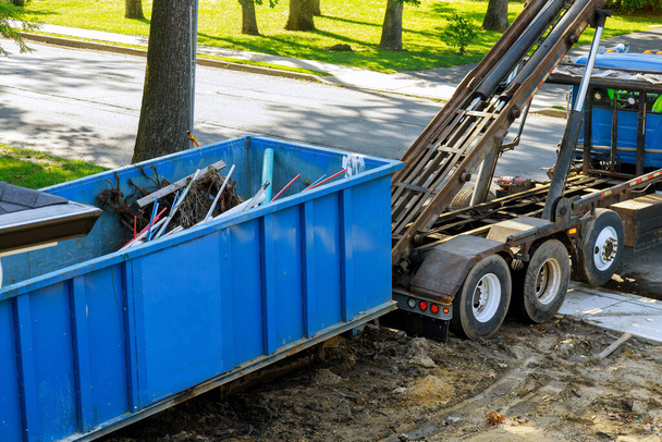 Contenedor de basura de metal cargando la basura puede desperdiciar los contenedores de basura de construcción en la renovación de la casa. - Foto, imagen