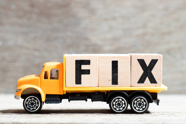 Camion tenere blocco lettera in parola fix su sfondo di legno - Foto, immagini
