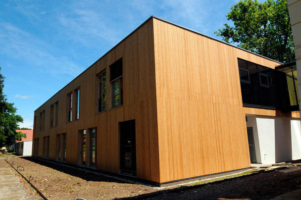 μοντέρνο ξύλινο σπίτι με ανοιχτό χρώμα ξύλου σε μια καλοκαιρινή μέρα - Φωτογραφία, εικόνα