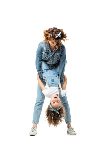 mother and daughter in denim outfits having fun isolated on white - 写真・画像