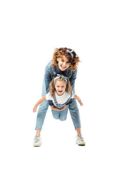 mother and daughter in denim outfits having fun isolated on white - Photo, image