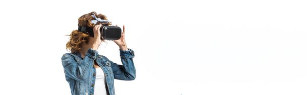 Frau im Jeans-Outfit und Virtual-Reality-Headset isoliert auf weißer, panoramischer Aufnahme - Foto, Bild