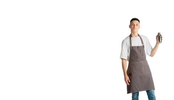 Isolated portrait of a young male caucasian barista or bartender in brown apron smiling - Fotó, kép