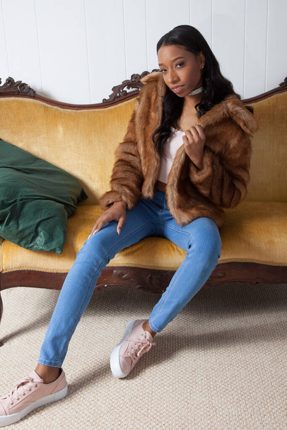 Belle Femme en manteau de fourrure, relaxante sur un canapé - Photo, image