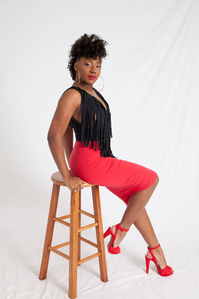 Sexy femme noire assise sur un tabouret - Photo, image
