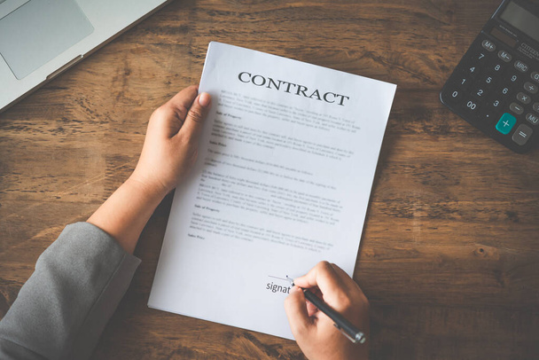 Stylo à main signant le contrat dans des documents importants. - Photo, image