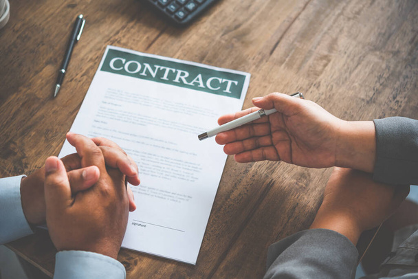 zakenman onderhandelt, adviseert en verklaart de kwestie van het overeen te komen contract om het contract te ondertekenen. - Foto, afbeelding