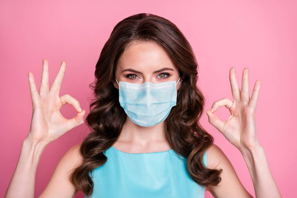 Close-up portrait of her she nice attractive content healthy wavy-haired girl wear safety gauze mask showing double ok-sign flue influenza viral disease recovery isolated pink pastel color background - Фото, изображение