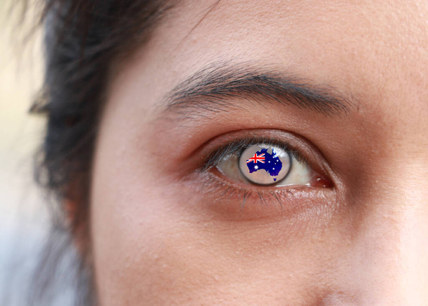 Volto umano con mappa australiana contorno con bandiera colore al centro dell'occhio o bulbo oculare. Profilo della mappa dipinta a occhio umano con la bandiera di Australia. - Foto, immagini