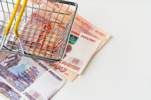Toy shopping cart with Russian rubles money. Living wage and purchasing power concept - Fotoğraf, Görsel