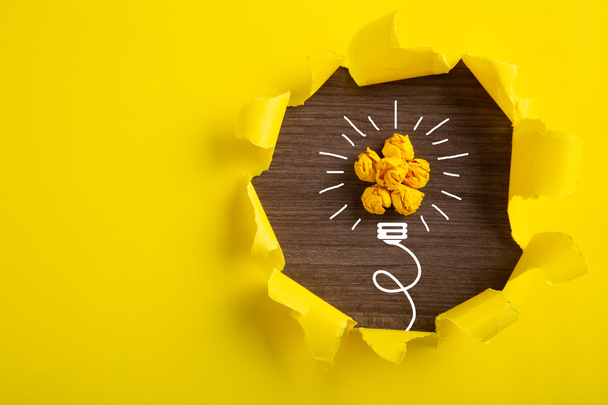 Kreatív ötlet, Inspiráció, Új ötlet és innovációs koncepció összegyűrt papírizzóval sárga alapon. - Fotó, kép
