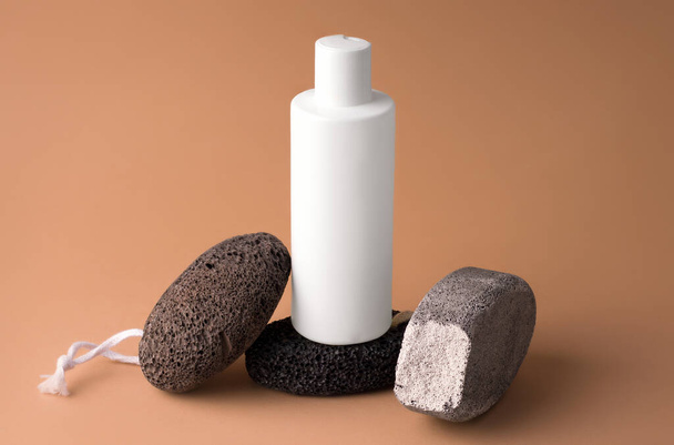 Burla de una botella blanca sobre un pedestal de piedras. Concepto de cosméticos - Foto, Imagen