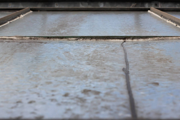 Χάσμα μεταξύ δύο γυάλινων πλακών σε ένα εγκαταλελειμμένο θερμοκήπιο - Φωτογραφία, εικόνα