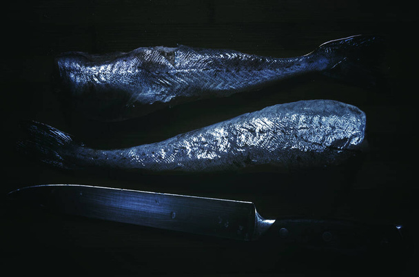 Tuore valkoinen kala pollock näkyy leikkuulauta veitsellä - Valokuva, kuva