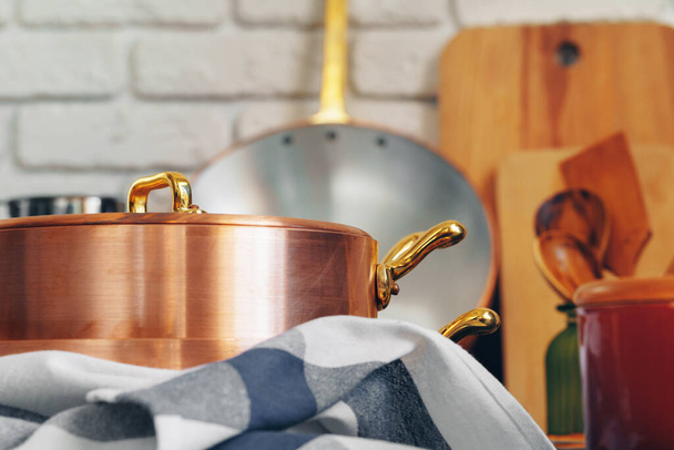 Copper cookware with wooden kitchen utensils close up - Foto, afbeelding