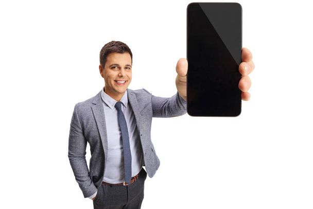 Professional young man showing a smartphone isolated on white background - Foto, Imagem