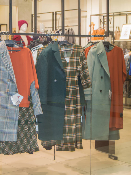 Uma coleção de Outono casual outerwear pendura em cabides em uma loja de moda. - Foto, Imagem