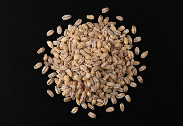 Vista superior de granos de cebada perla aislados sobre fondo negro, primer plano - Foto, imagen