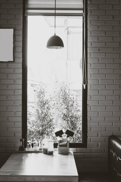 Lamp and table in restaurant with the grain tone image of black and white. - Fotó, kép