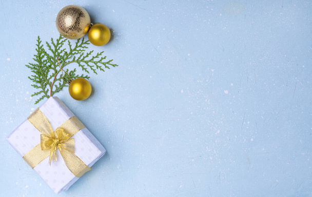 Weihnachten weiß eco Geschenk und goldene Weihnachtskugeln auf blauem Zementhintergrund - Foto, Bild