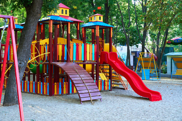 parco giochi per bambini in un parco cittadino la mattina presto, varie altalene e giostre - Foto, immagini