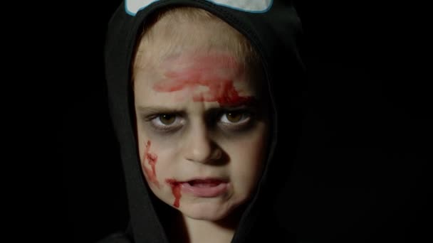 Halloween, chica enojada con maquillaje de sangre en la cara. Niño vestido como esqueleto de miedo, posando, haciendo caras - Imágenes, Vídeo