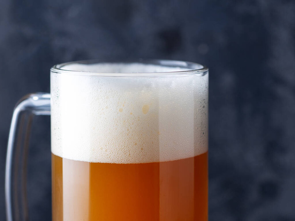Pivní hrnek nefiltrovaného pšeničného piva zblízka s velkým pěnovým víčkem - Fotografie, Obrázek