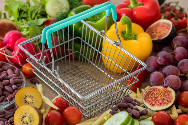 Порожній кошик. Багато їжі, овочів і фруктів навколо. Концепція підвищення цін, інфляції та дорожчого харчування
 - Фото, зображення