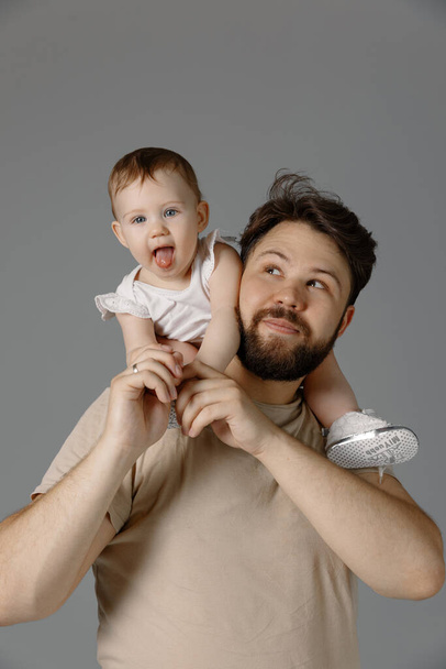 Dad and baby having fun. Father holding daughter on shoulders, isolated - 写真・画像