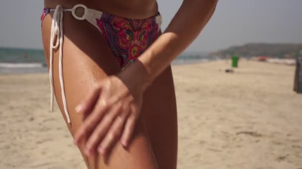 Slim donna sexy sulla spiaggia del mare utilizza un agente abbronzante e la protezione della pelle - Filmati, video