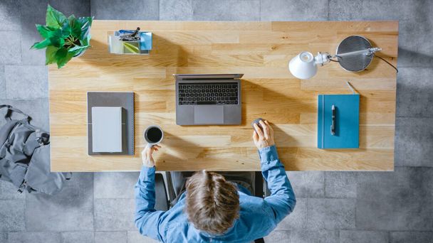 Top View Shot : Homme d'affaires assis au bureau en bois travaille sur un ordinateur portable dans son bureau à domicile. Il boit du café, Types, Ecrit des e-mails, Surfe sur Internet, Designs Software, Boutique en ligne - Photo, image