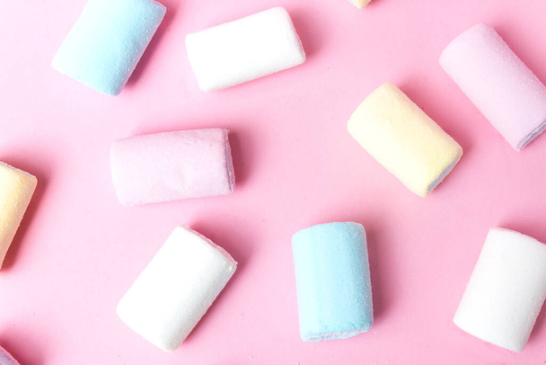 Kleurrijke marshmallows plaatsen op roze plat. Marshmallow pastel kleuren op roze achtergrond - Foto, afbeelding
