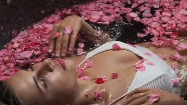 Jonge vrouw in bloemenbad. Spa ontspanning en behandeling - Video