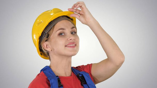 Female construction worker greeting on gradient background. - Фото, изображение