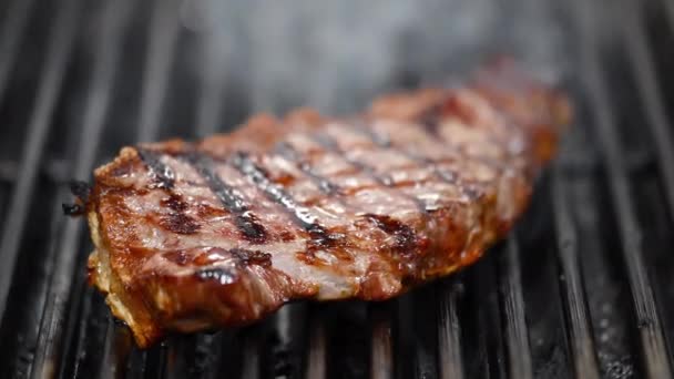 Közel a finom marhahús steak lángoló grill. - Felvétel, videó