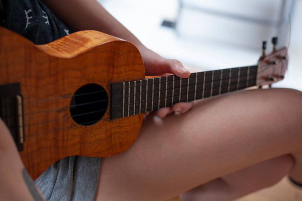 The girl plays on the ukulele. Lesson playing the guitar. - Foto, Bild