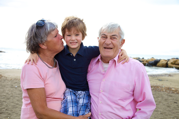Onnellinen lapsi halaamassa isovanhempia kesällä
 - Valokuva, kuva