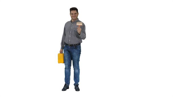 Casual man with brush and some liquid looking what to paint and smiling to camera on white background. - Foto, immagini