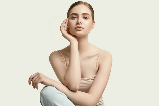 Ritratto di attraente giovane donna bruna in jeans posa su sfondo bianco studio - Foto, immagini