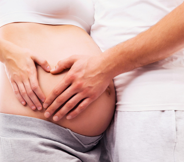 Body of a pregnant woman and a loving man - Фото, зображення