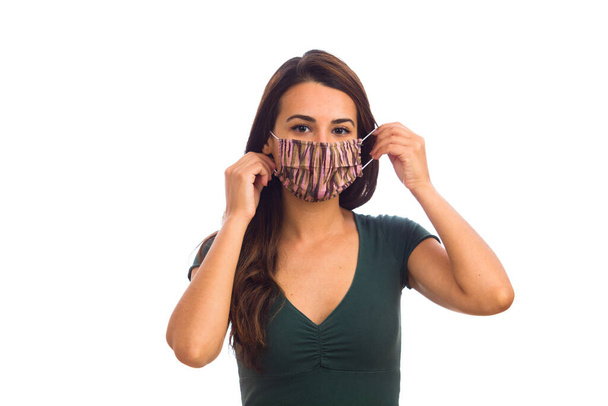 Beautiful young woman portrait wearing a mask on a white background. - 写真・画像