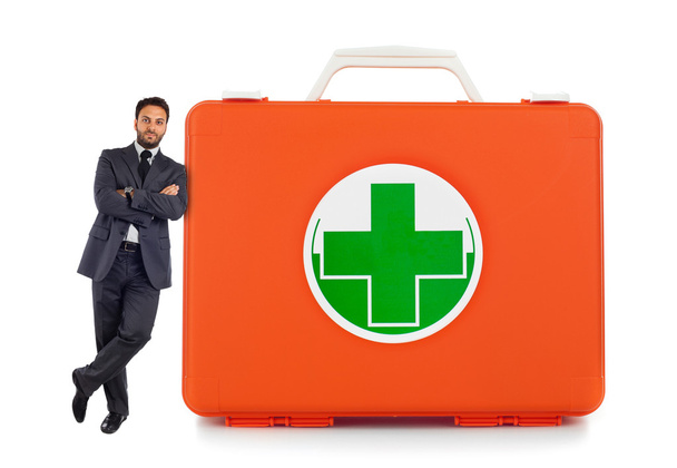 Young business man leaning against near the first aid box - Photo, Image